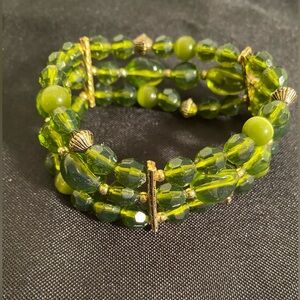 Vintage stretch bracelet with faceted green lucite, metal and cat’s eye beads.